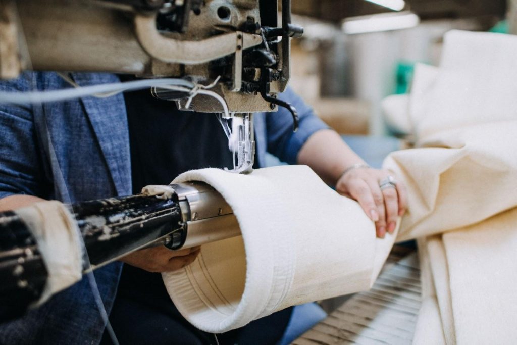 person sewing filter media